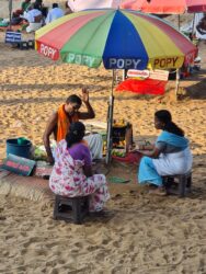 Morgens sitzen Hindupriester an einem heiligen Ort am Strand und segnen die Menschen, die zu ihnen kommen